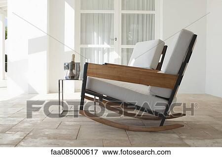 Rocking chairs and champagne bucket on patio View Large Photo Image Stock Photo - Rocking chairs and champagne bucket on patio. Fotosearch