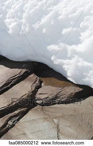Stock Image - Snow on stones. Fotosearch