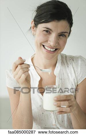 Woman eating yogurt, portrait View Large Photo Image Stock Photo - Woman eating yogurt, portrait. Fotosearch