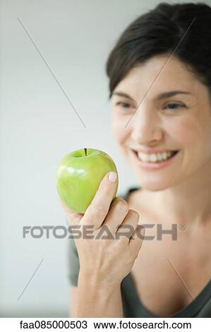 Woman holding green apple View Large Photo Image Stock Image - Woman holding green apple. Fotosearch