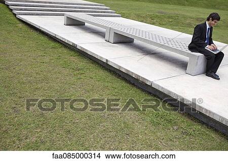Picture - Young businessman using laptop computer outdoors. Fotosearch