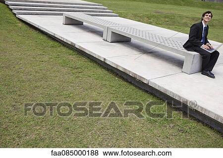 Young businessman using laptop computer outdoors View Large Photo Image Stock Photo - Young businessman using laptop computer outdoors. Fotosearch