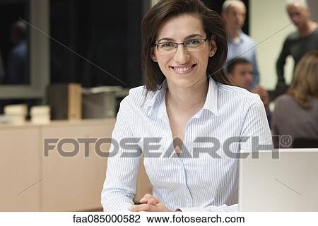 Stock Image - Young businesswoman in office, portrait. Fotosearch