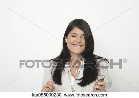 Young businesswoman listing to music on mp3 player View Large Photo Image Stock Image - Young businesswoman listing to music on mp3 player. Fotosearch