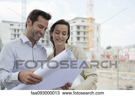 Architects reviewing blueprint in construction site View Large Photo Image Stock Image - Architects reviewing blueprint in construction site. Fotosearch