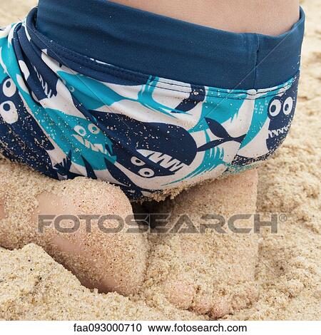 Boy sitting on sand at the beach, close-up View Large Photo Image Stock Image - Boy sitting on sand at the beach, close-up. Fotosearch