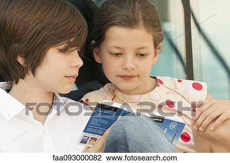 Brother and sister reading guidebook together View Large Photo Image Stock Image - Brother and sister reading guidebook together. Fotosearch
