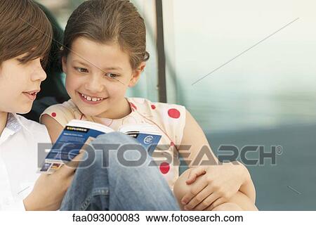 Brother and sister reading guidebook together View Large Photo Image Stock Image - Brother and sister reading guidebook together. Fotosearch