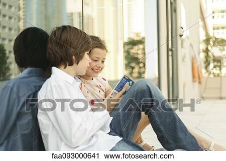 Brother and sister reading guidebook together View Large Photo Image Stock Image - Brother and sister reading guidebook together. Fotosearch