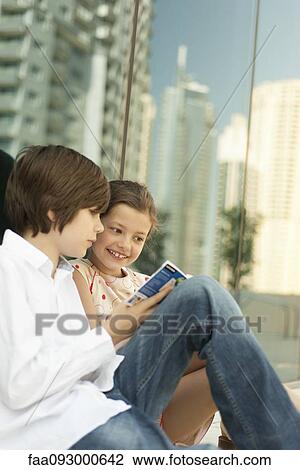 Brother and sister reading guidebook together View Large Photo Image Stock Image - Brother and sister reading guidebook together. Fotosearch