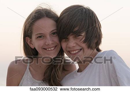 Stock Image - Brother and sister together outdoors, portrait. Fotosearch