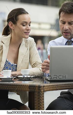 Stock Image - Business associates collaborating on project using laptop computer. Fotosearch