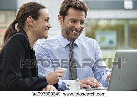 Business associates having coffee while collaborating on project View Large Photo Image Stock Photo - Business associates having coffee while collaborating on project. Fotosearch