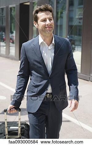 Businessman pulling luggage View Large Photo Image Picture - Businessman pulling luggage. Fotosearch