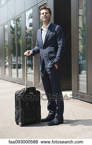 Businessman standing and waiting with luggage View Large Photo Image Stock Photo - Businessman standing and waiting with luggage. Fotosearch