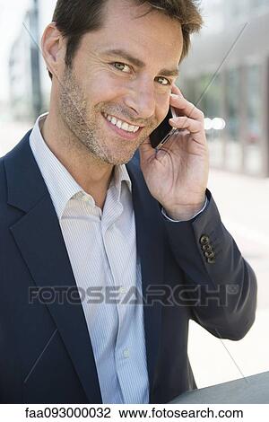 Businessman talking on cell phone outdoors View Large Photo Image Stock Image - Businessman talking on cell phone outdoors. Fotosearch