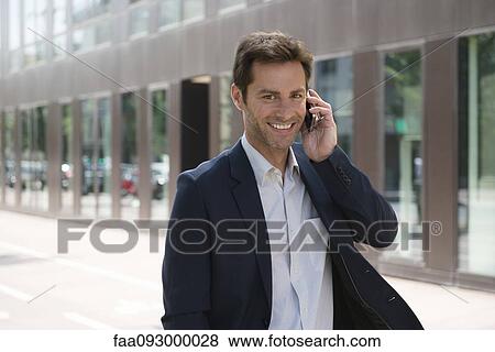 Businessman talking on cell phone outdoors View Large Photo Image Stock Photo - Businessman talking on cell phone outdoors. Fotosearch
