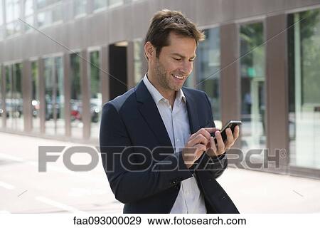 Businessman using smartphone outdoors View Large Photo Image Stock Photo - Businessman using smartphone outdoors. Fotosearch