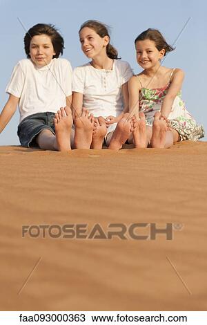 Children sitting on sand dune View Large Photo Image Stock Image - Children sitting on sand dune. Fotosearch