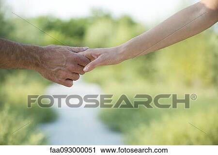 Couple hesitantly hold hands, close-up View Large Photo Image Stock Image - Couple hesitantly hold hands, close-up. Fotosearch