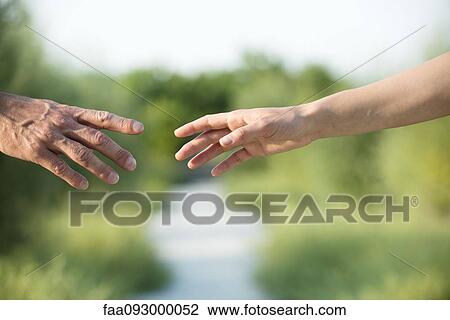 Couple reaching out to hold hands View Large Photo Image Stock Image - Couple reaching out to hold hands. Fotosearch