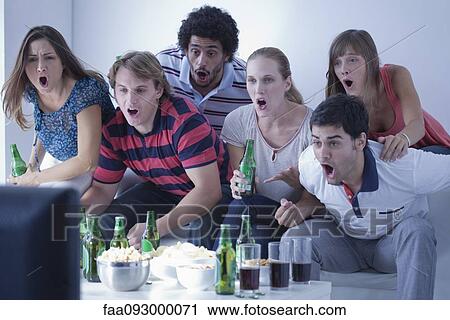 Stock Image - Friends watching sports match on television together. Fotosearch