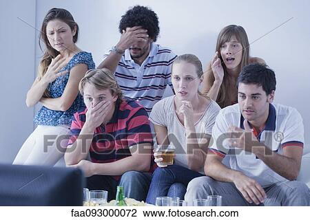 Stock Image - Friends watching sports match on television together express disappointment at team's performance. Fotosearch