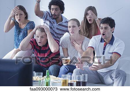 Stock Image - Friends watching sports match on television together express disappointment at team's performance. Fotosearch