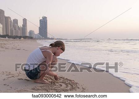 Girl drawing in sand on beach View Large Photo Image Stock Image - Girl drawing in sand on beach. Fotosearch