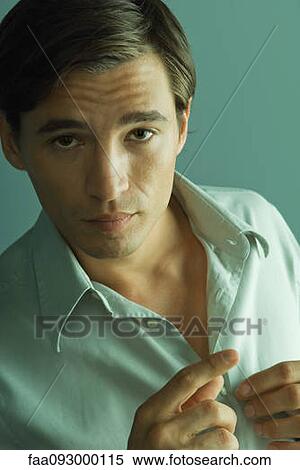 Handsome man buttoning shirt, looking at camera View Large Photo Image Stock Photography - Handsome man buttoning shirt, looking at camera. Fotosearch