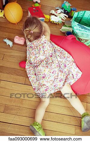 Little girl lying on floor with toys, overhead view View Large Photo Image Stock Photo - Little girl lying on floor with toys, overhead view. Fotosearch