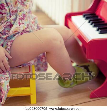 Stock Photography - Little girl playing with toy piano, cropped. Fotosearch