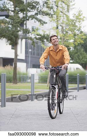 Man in business attire riding bicycle View Large Photo Image Stock Photo - Man in business attire riding bicycle. Fotosearch