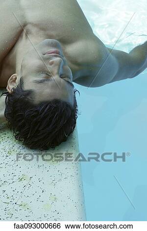 Man lying next to pool View Large Photo Image Stock Photograph - Man lying next to pool. Fotosearch