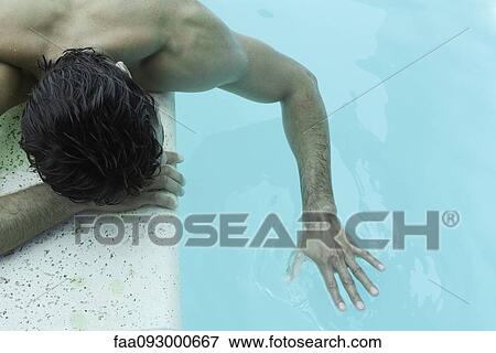 Man lying next to pool, touching water View Large Photo Image Stock Photo - Man lying next to pool, touching water. Fotosearch