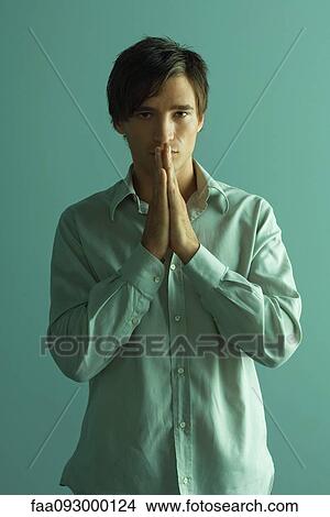 Man with hands clasped in prayer, looking at camera View Large Photo Image Picture - Man with hands clasped in prayer, looking at camera. Fotosearch