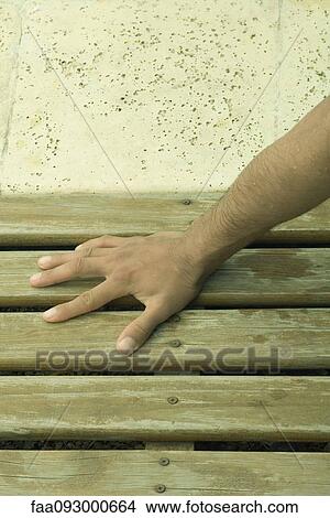 Picture - Man's hand on wooden deck. Fotosearch