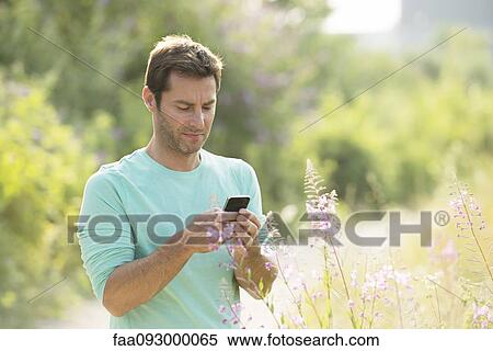 Mature man text messaging while enjoying the great outdoors View Large Photo Image Stock Photography - Mature man text messaging while enjoying the great outdoors. Fotosearch