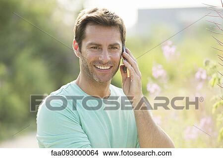 Mature man using cell phone while enjoying the great outdoors View Large Photo Image Picture - Mature man using cell phone while enjoying the great outdoors. Fotosearch