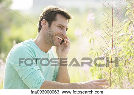 Mature man using cell phone while enjoying the great outdoors View Large Photo Image Stock Image - Mature man using cell phone while enjoying the great outdoors. Fotosearch