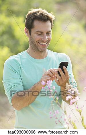 Mature man using cell phone while enjoying the great outdoors View Large Photo Image Stock Photograph - Mature man using cell phone while enjoying the great outdoors. Fotosearch