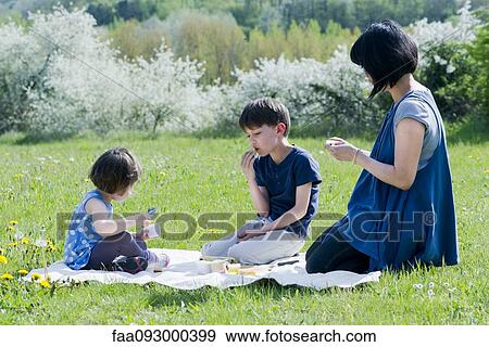 Mother and children having picnic in meadow View Large Photo Image Stock Photo - Mother and children having picnic in meadow. Fotosearch