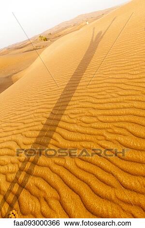 Shadow of person with arms raised cast on desert sand View Large Photo Image Stock Photograph - Shadow of person with arms raised cast on desert sand. Fotosearch