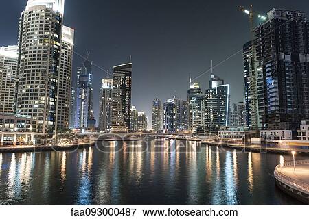 Skyscrapers illuminating marina by night View Large Photo Image Stock Photo - Skyscrapers illuminating marina by night. Fotosearch
