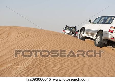 Sports utility vehicles driving up desert sand dune View Large Photo Image Stock Photography - Sports utility vehicles driving up desert sand dune. Fotosearch