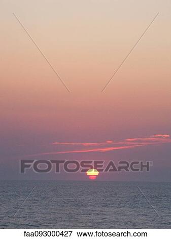 Stock Photo - Sun setting over sea. Fotosearch