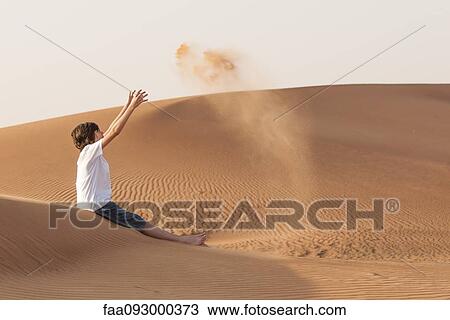 Teenage boy playfully tossing sand into air View Large Photo Image Stock Image - Teenage boy playfully tossing sand into air. Fotosearch