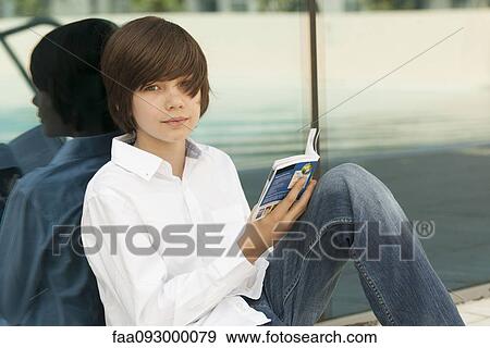 Teenage boy reading guidebook View Large Photo Image Stock Photo - Teenage boy reading guidebook. Fotosearch