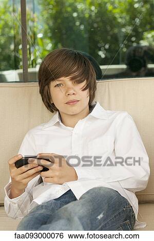 Teenage boy using cell phone View Large Photo Image Stock Photograph - Teenage boy using cell phone. Fotosearch