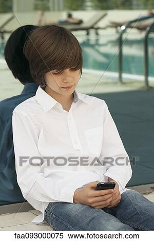 Stock Photography - Teenage boy using cell phone. Fotosearch
